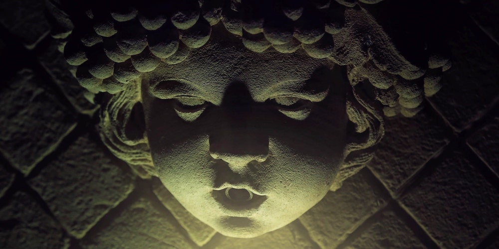 Escultura de un rostro en la oscuridad